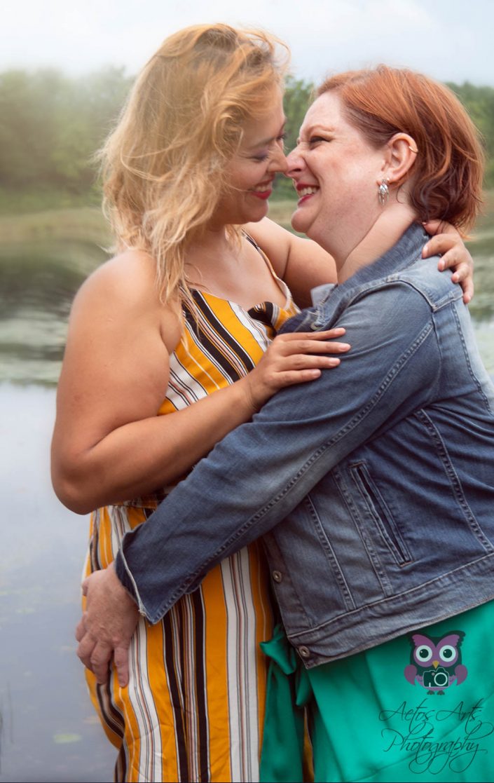Elegant Women pose near a lake during an engagement session
