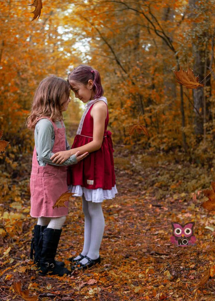 beautiful sisters sharing a moment in the fall woods