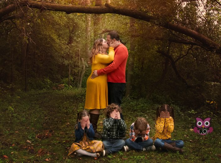 Parents Kissing in the woods while children cover their eyes