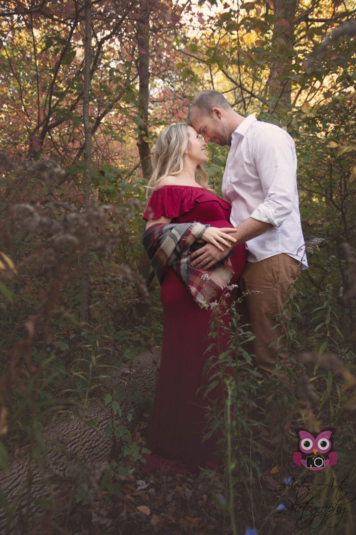 Beautiful couple expecting baby posing in the woods
