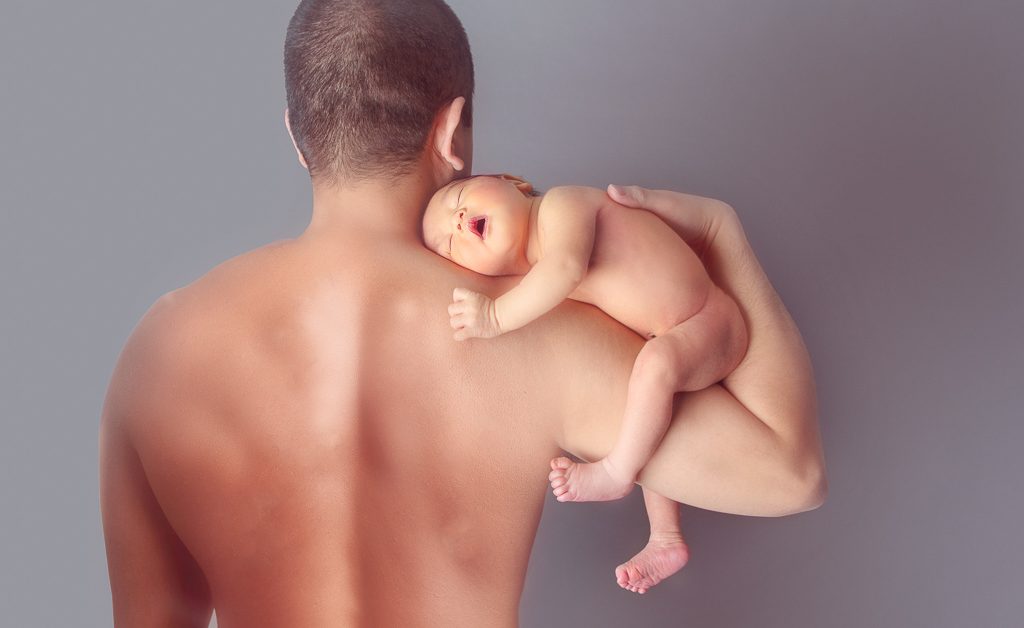 Newborn Baby Boy poses on Daddy's Arm