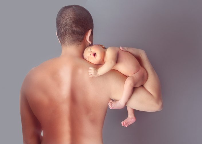 Newborn Baby Boy poses on Daddy's Arm