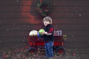 Toddler boy poses for photo outdoors in Christmas Themed set