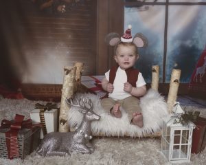 Beautiful baby poses for Christmas photos on a little bed in Cambridge Ontario
