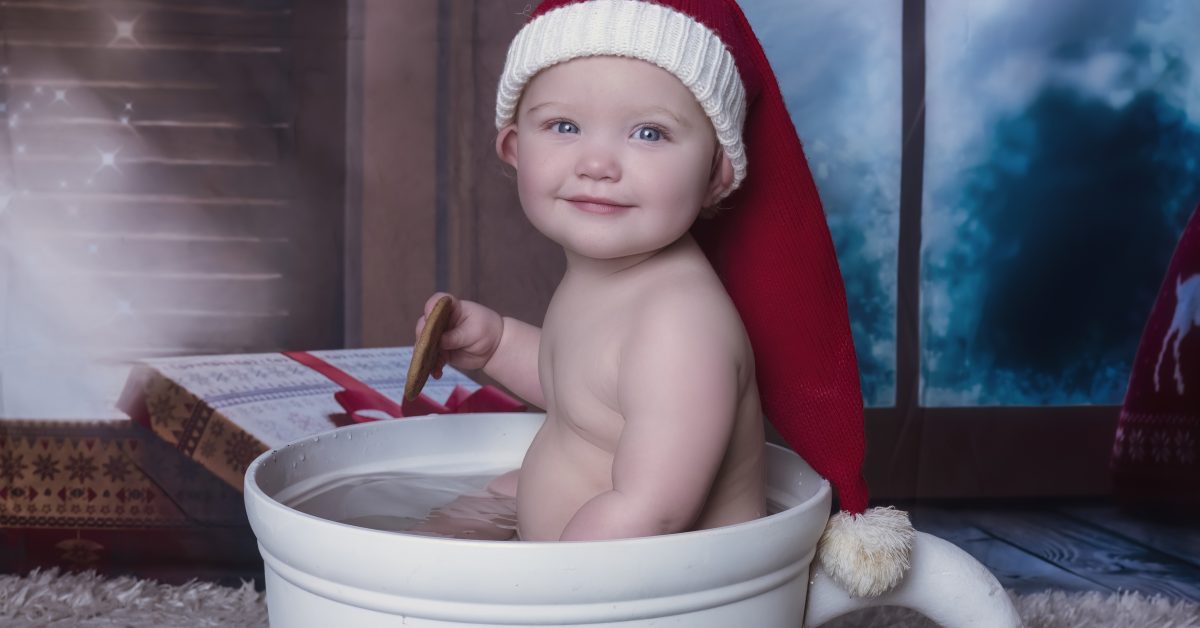 Adorable baby sits in hot cocoa cup for Christmas Themed Sitter Session