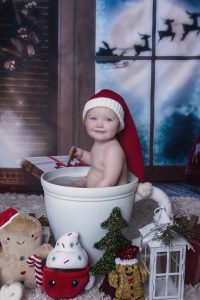 Adorable baby sits in hot cocoa cup for Christmas Themed Sitter Session