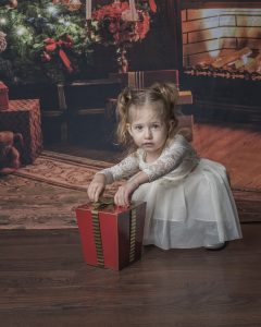 Toddler Girl opens gift at a Christmas MIni Session in Cambridge Ontario